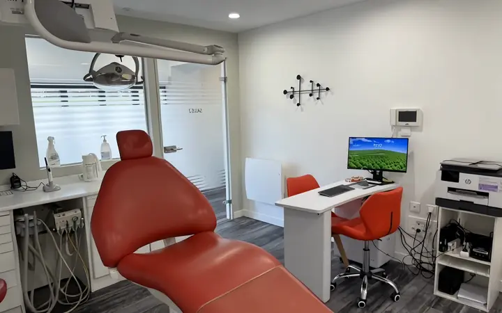 Une salle de soins au fauteuil rouge, dans la visite vidéo d’un cabinet dentaire